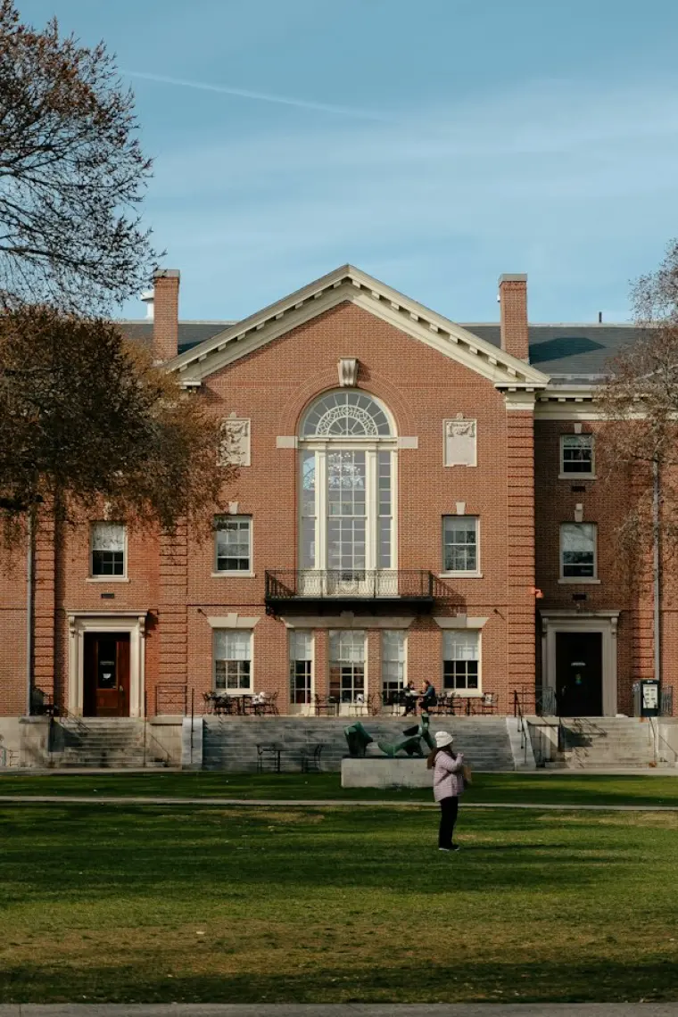 A brick academic building facing an open campus quad